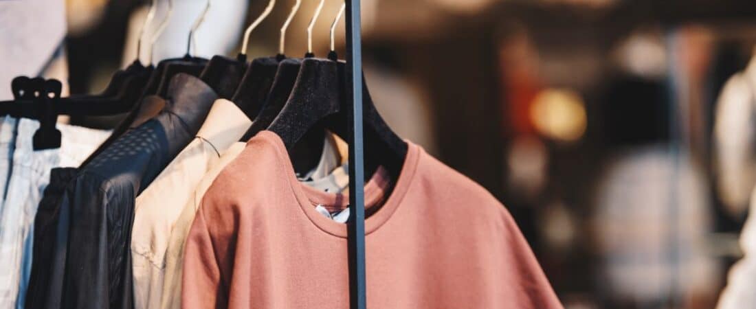 Shirts hanging on a clothing rack inside a retail store.