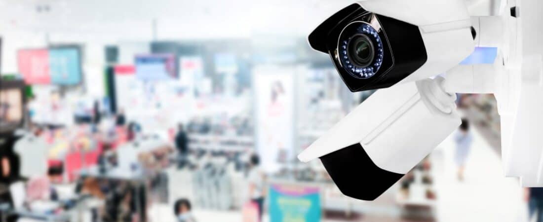 Modern public CCTV camera with blur interior shopping mall background. Concept of surveillance