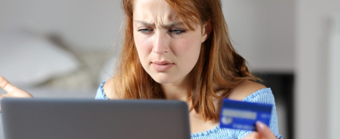 Confused woman buying online with credit card.