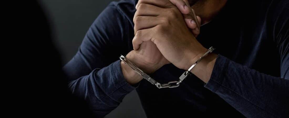 Man with handcuffs in interrogation room.