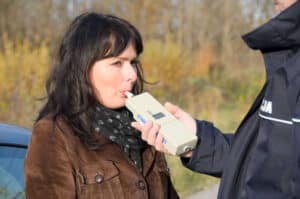 woman performing breathalyzer test