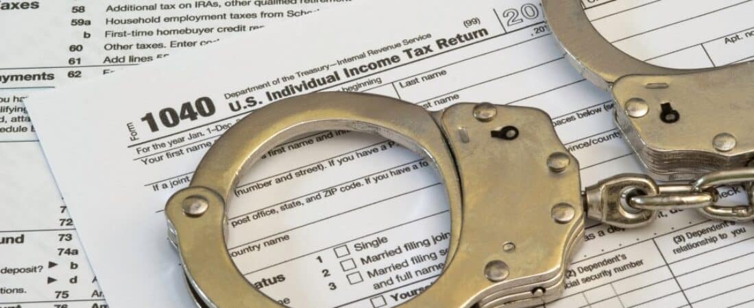 Tax fraud concept, tax forms with handcuffs