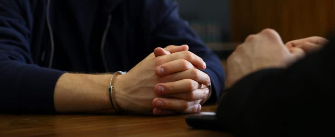 A criminal defense attorney speaking with his client about potential defenses.